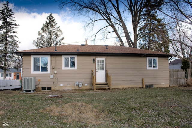 back of property with a lawn and central AC