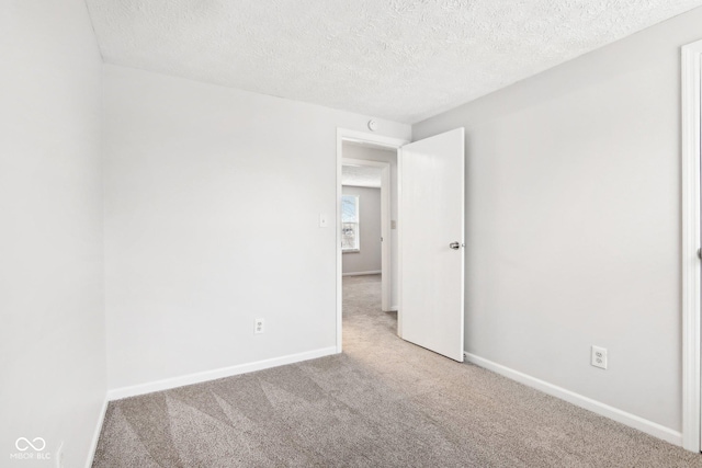 unfurnished room with a textured ceiling and carpet