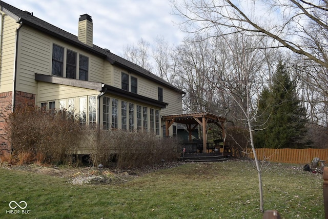 rear view of house featuring a gazebo and a yard