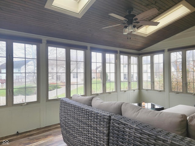 sunroom / solarium with a wealth of natural light, ceiling fan, wooden ceiling, and lofted ceiling with skylight