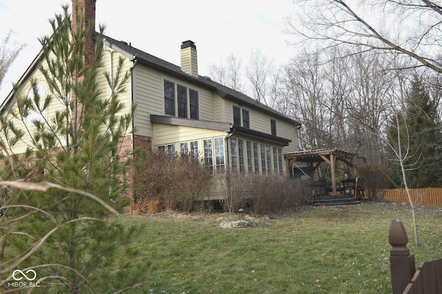 rear view of property with a pergola and a yard