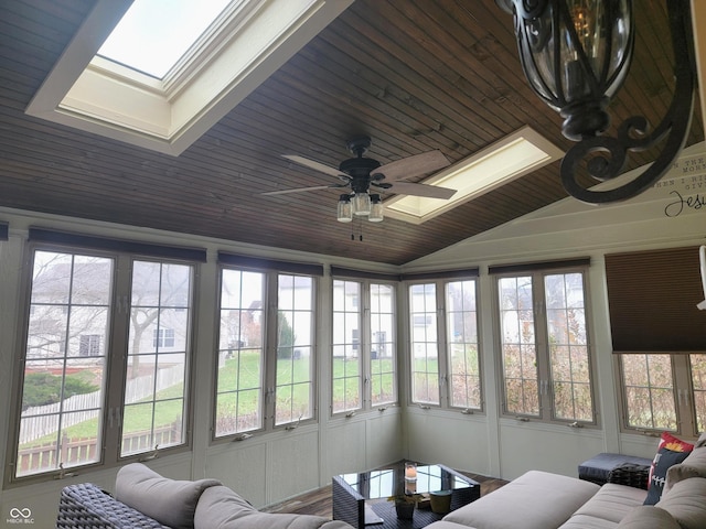 sunroom featuring a healthy amount of sunlight, ceiling fan, vaulted ceiling with skylight, and wooden ceiling