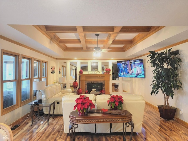 living room with beam ceiling, ceiling fan, coffered ceiling, hardwood / wood-style floors, and ornamental molding