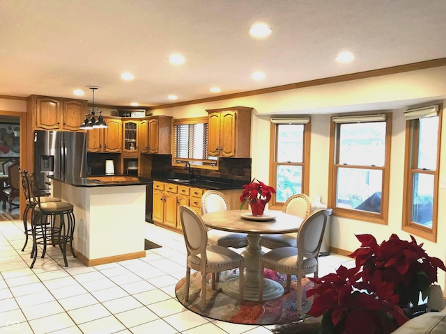 kitchen with sink, tasteful backsplash, stainless steel fridge with ice dispenser, pendant lighting, and ornamental molding