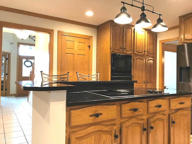 kitchen featuring black microwave, crown molding, electric stovetop, light tile patterned floors, and hanging light fixtures