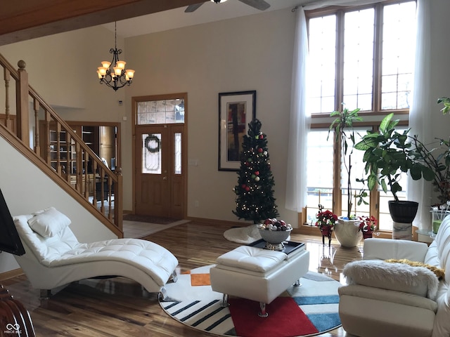 living room featuring ceiling fan with notable chandelier and wood-type flooring