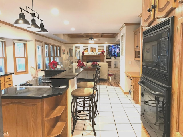 kitchen featuring a kitchen breakfast bar, ornamental molding, ceiling fan, black appliances, and light tile patterned floors