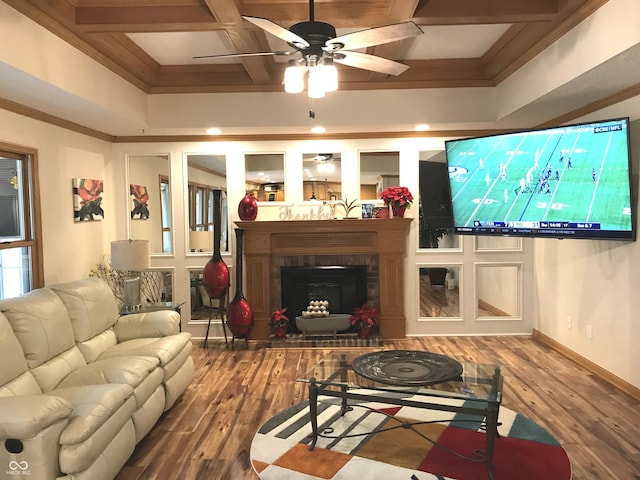 living room featuring ceiling fan, coffered ceiling, dark hardwood / wood-style flooring, beamed ceiling, and a fireplace