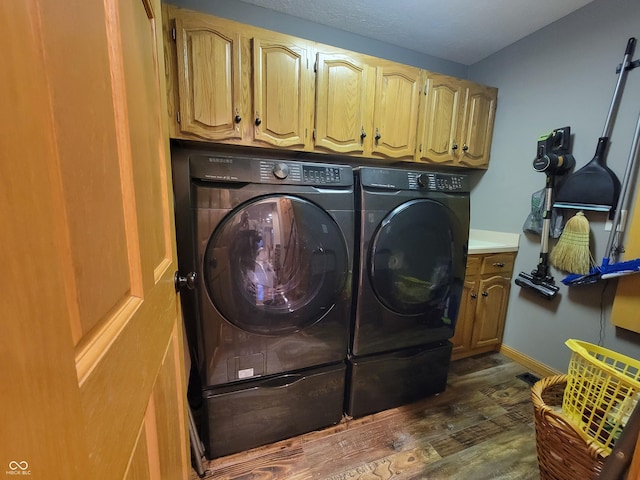 laundry room with separate washer and dryer, dark hardwood / wood-style flooring, and cabinets