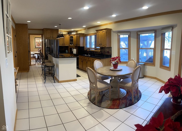 tiled dining space with sink and ornamental molding