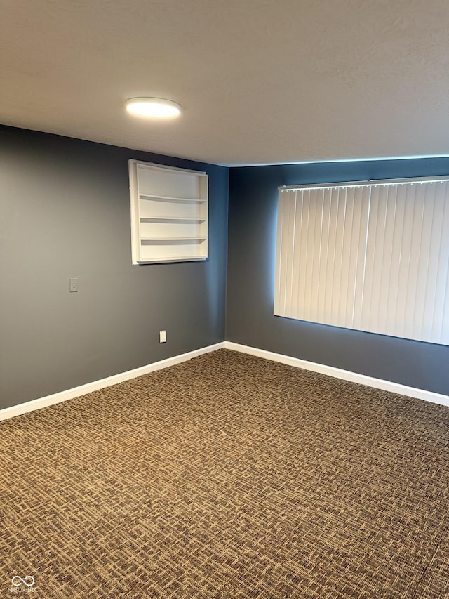 carpeted spare room with built in shelves