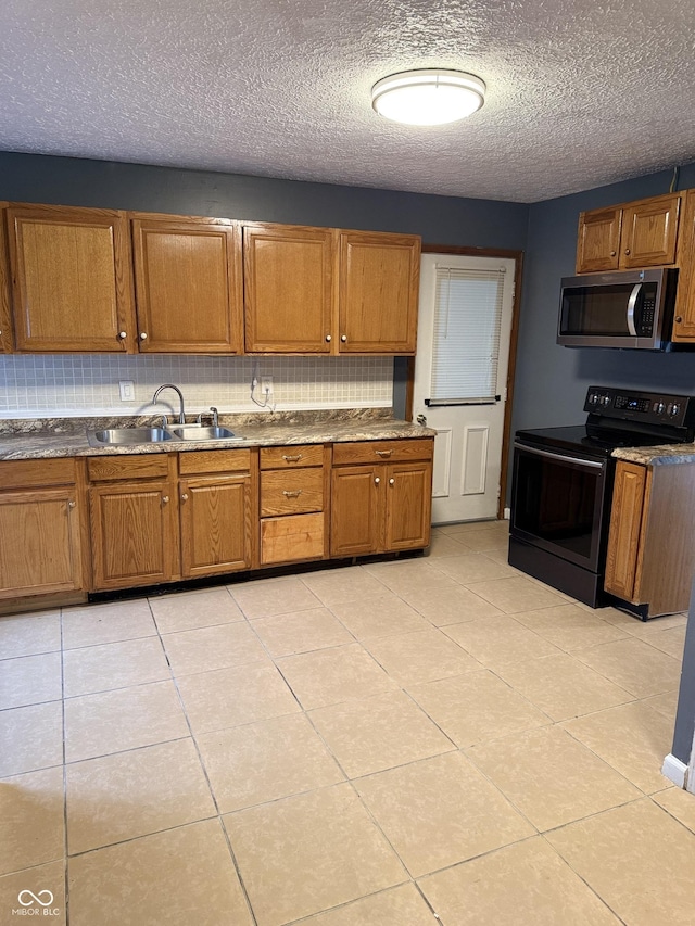 kitchen with black / electric stove, sink, light tile patterned floors, and a textured ceiling