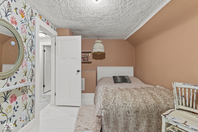 bedroom featuring a textured ceiling and lofted ceiling