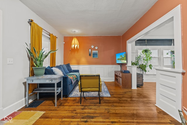 living room featuring a textured ceiling and dark wood-type flooring