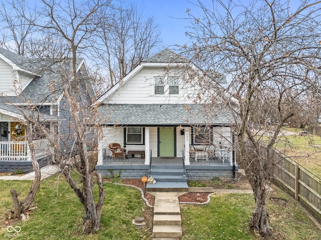 bungalow-style house featuring covered porch and a front yard