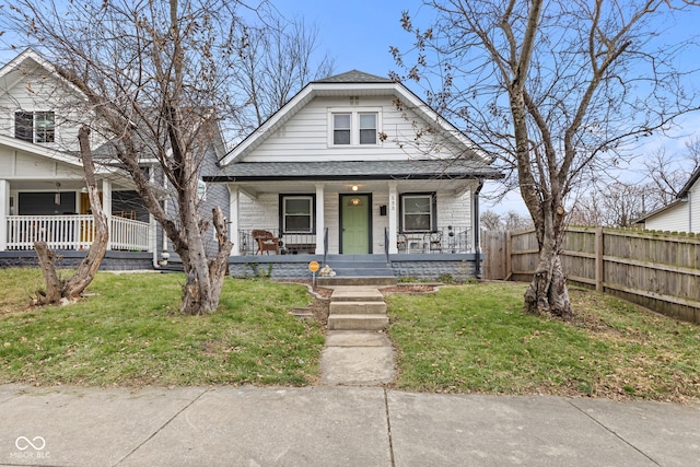 bungalow with covered porch and a front yard