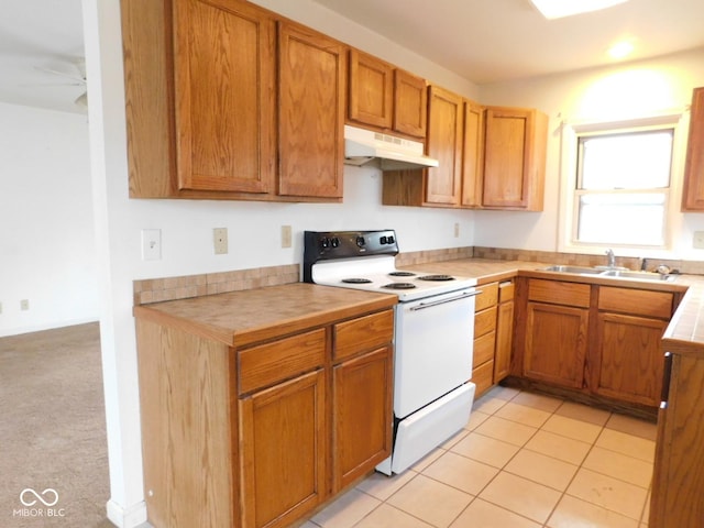 kitchen with light tile patterned flooring, white electric range, sink, tile counters, and ceiling fan