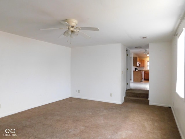 carpeted spare room with ceiling fan