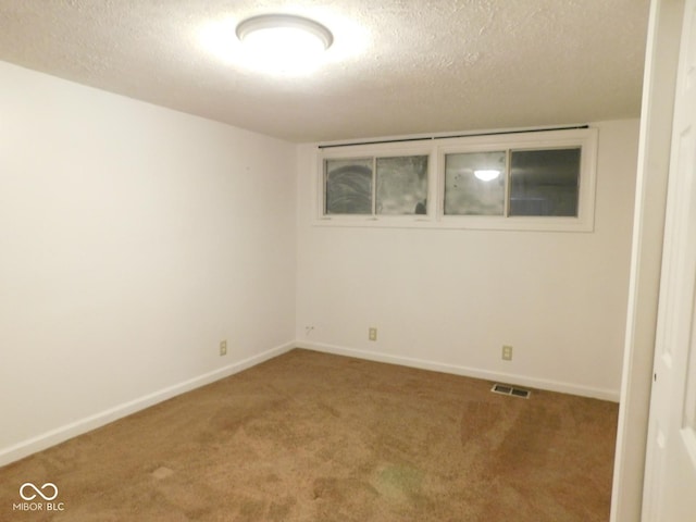 unfurnished room featuring carpet floors and a textured ceiling