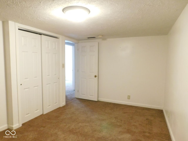 unfurnished bedroom with a closet, a textured ceiling, and carpet flooring