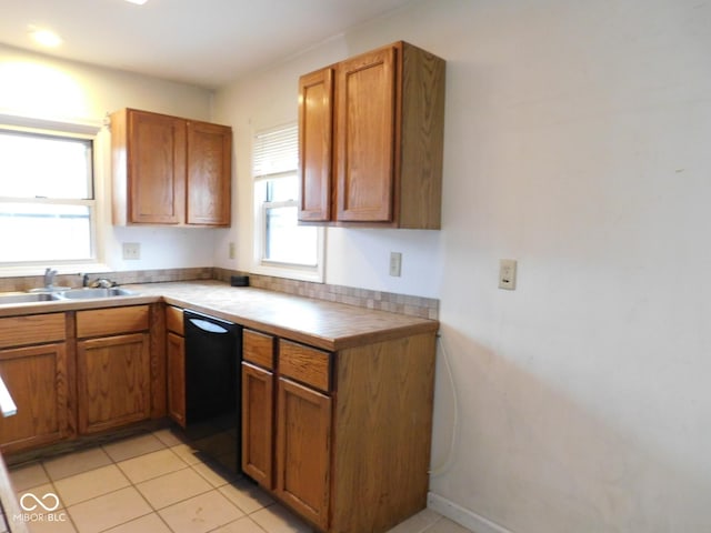 kitchen with dishwasher, sink, and light tile patterned flooring