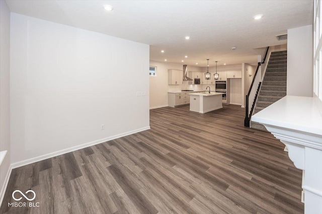 unfurnished living room featuring sink and dark wood-type flooring