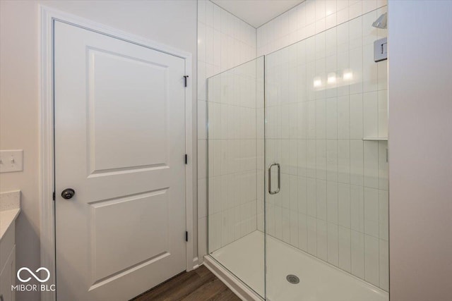 bathroom with a shower with door and hardwood / wood-style flooring