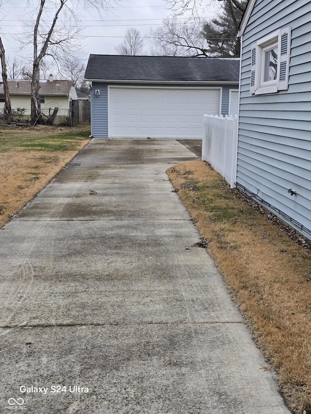 detached garage featuring fence