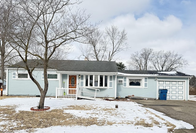 ranch-style home with aphalt driveway, an attached garage, and a shingled roof