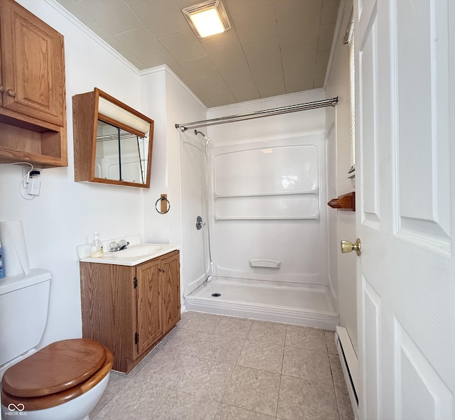 bathroom with a baseboard heating unit, a shower stall, toilet, and crown molding