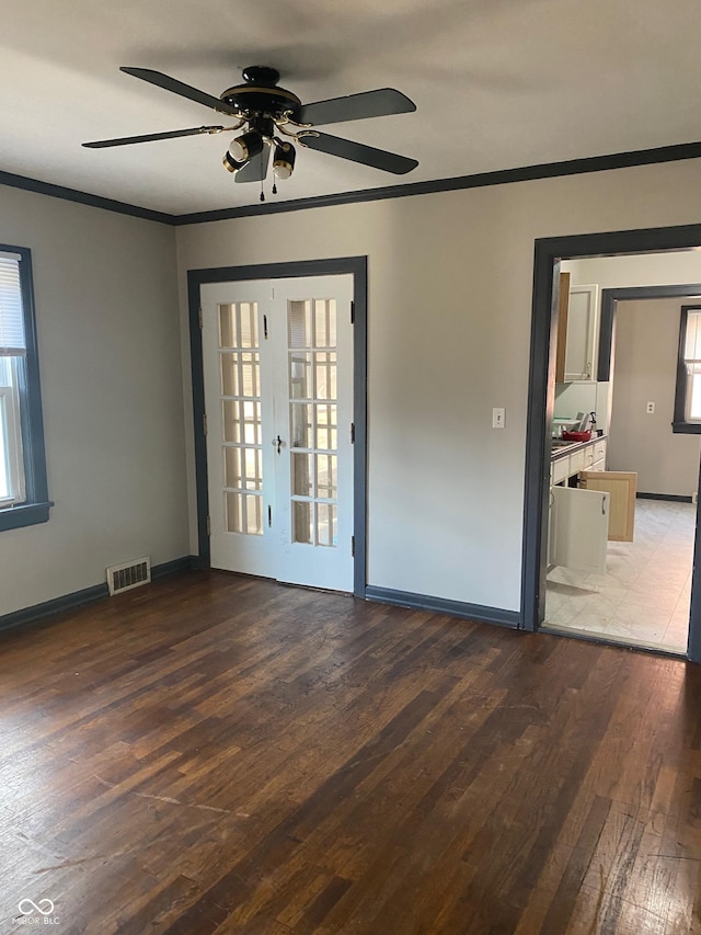 empty room featuring crown molding, french doors, ceiling fan, and dark hardwood / wood-style floors