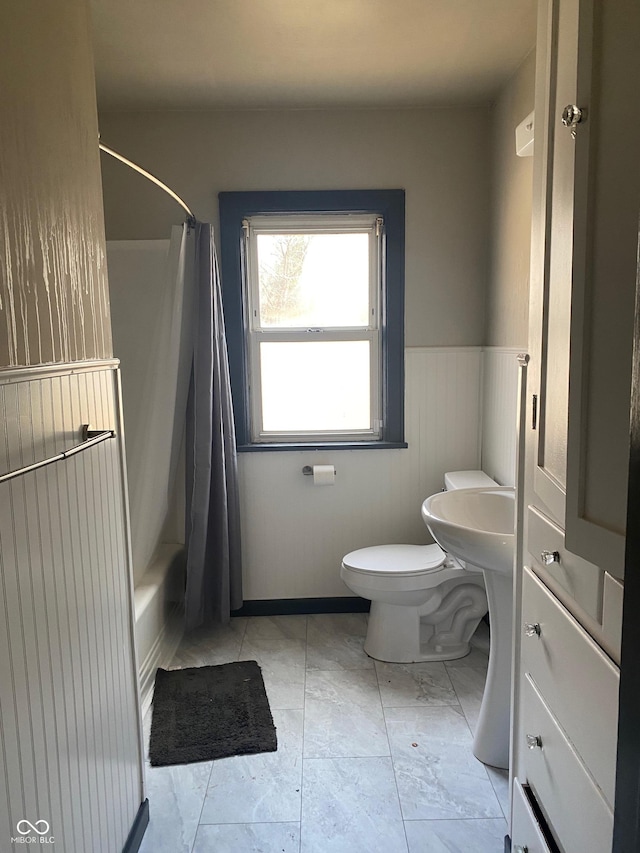 bathroom featuring toilet and shower / bathtub combination with curtain