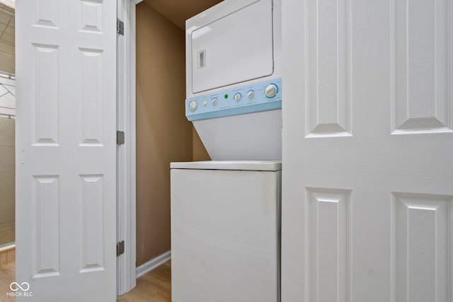 laundry area featuring light hardwood / wood-style flooring and stacked washer / drying machine