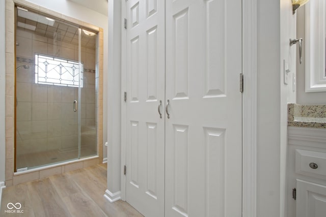 bathroom with vanity, an enclosed shower, and hardwood / wood-style flooring