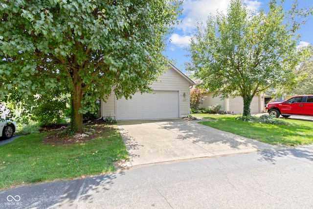 obstructed view of property featuring a garage, an outbuilding, and a front lawn