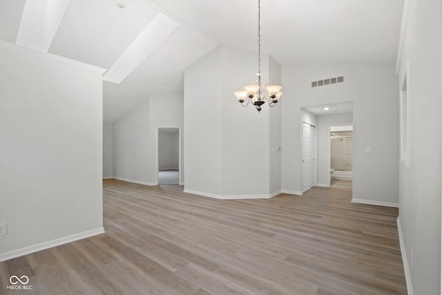 interior space featuring vaulted ceiling, light wood-type flooring, and a chandelier