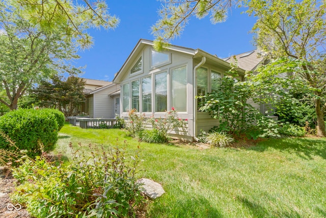 view of side of property featuring a yard and a sunroom