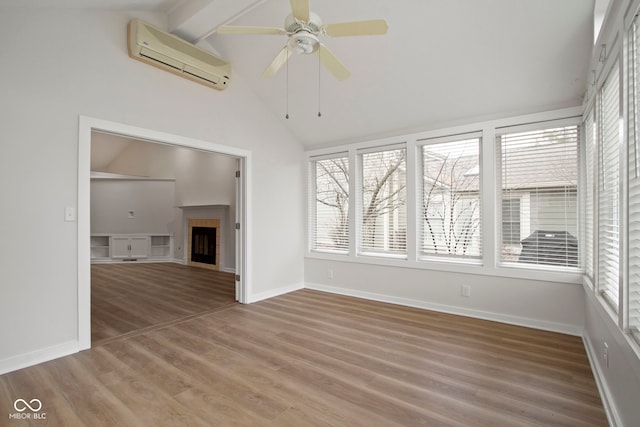 unfurnished living room featuring a wall mounted air conditioner, vaulted ceiling with beams, ceiling fan, and hardwood / wood-style floors