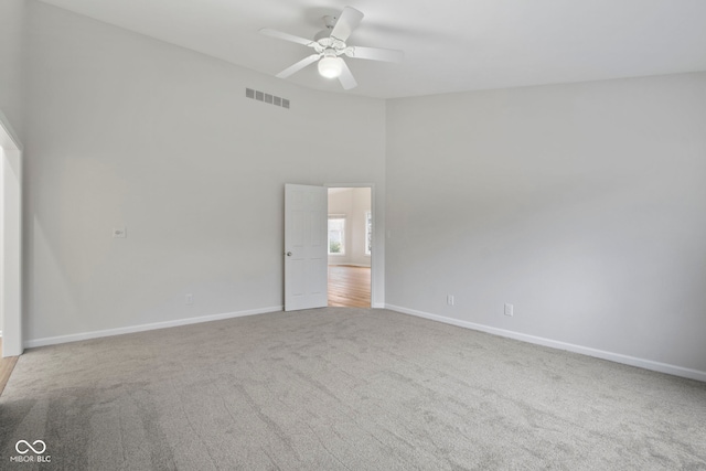 carpeted spare room with ceiling fan