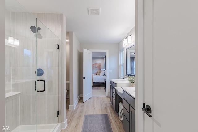 bathroom featuring vanity, hardwood / wood-style flooring, and a shower with shower door