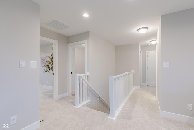 hallway featuring light colored carpet