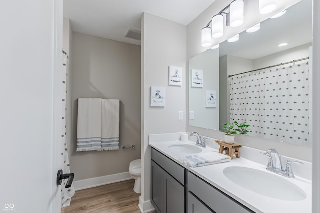 bathroom featuring vanity, toilet, wood-type flooring, and walk in shower