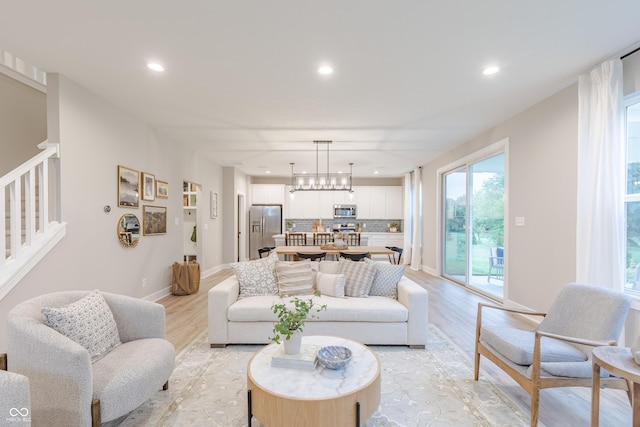 living room with a chandelier and light hardwood / wood-style flooring