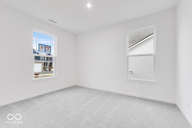 spare room with baseboards, visible vents, and carpet flooring