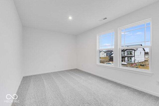 carpeted empty room featuring recessed lighting, visible vents, and baseboards