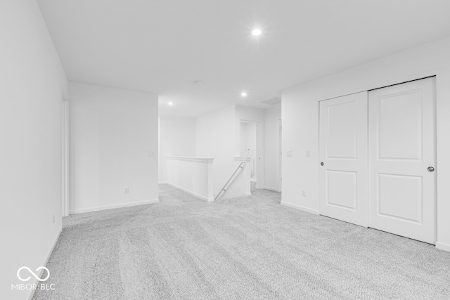 empty room featuring recessed lighting, baseboards, and light colored carpet