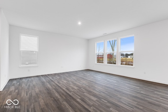 spare room with dark wood-style floors and baseboards