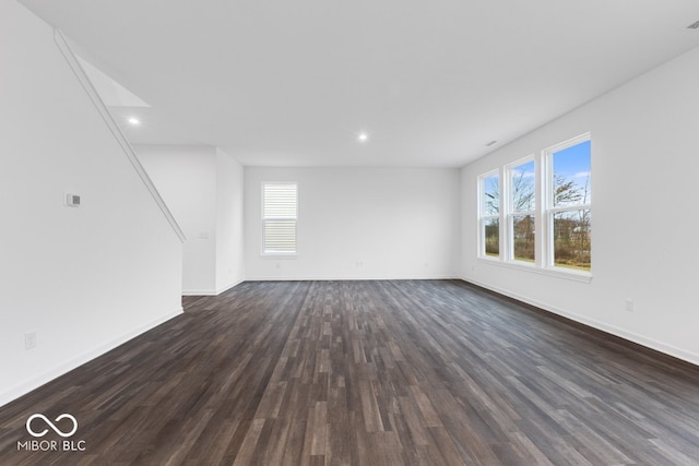 unfurnished living room featuring dark wood-type flooring, recessed lighting, and baseboards