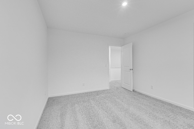 spare room featuring carpet floors and baseboards