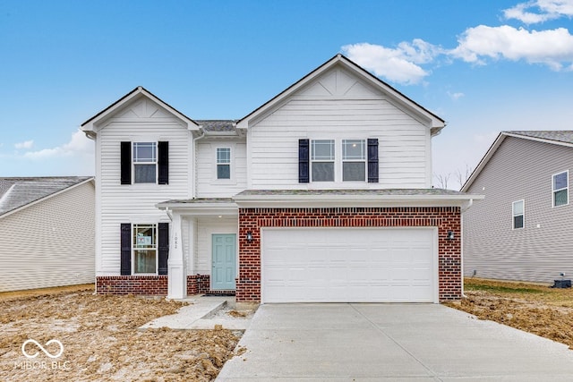 traditional-style home featuring a garage, a shingled roof, concrete driveway, and brick siding